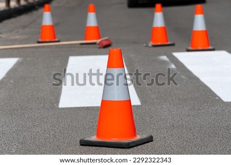 Road repair, cone in the foreground. Traffic cone. New road markings. Traffic line painting.