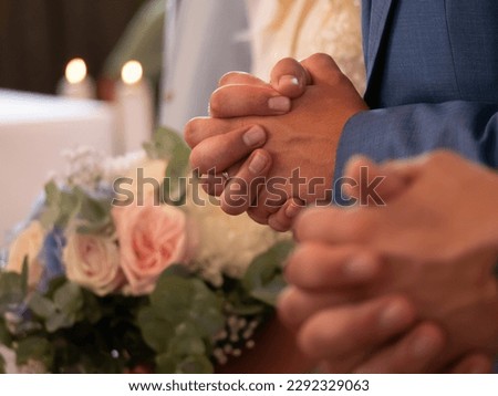 CLOSE UP, DOF: Groom's hands praying at traditional wedding ceremony in church. Prayer as a part of traditional protocol at wedding mass. An authentic view of clasped male hands at religious ritual.