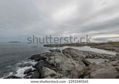 View of rocky shoreline with alot of clouds and rainy weather on Lofoten islands, Norway