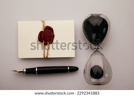 Black envelope with red wax seal and stamp on dark wooden background.
