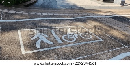 Pedestrian and cyclist symbols are enclosed in white frames that are well lit by sunlight. Roads that have special lanes for exercise walkers and cyclists are painted in the streets of the park.
