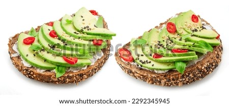 Avocado toasts - bread with avocado slices, pieces of chilli pepper and black sesame isolated on white background. Royalty-Free Stock Photo #2292345945