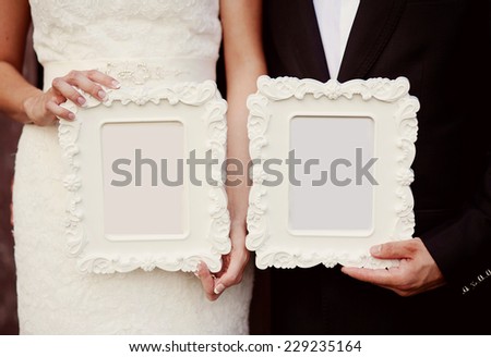 Bride and groom holding vintage photo frames, cut out