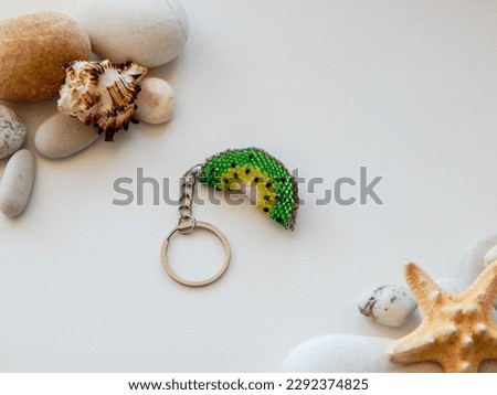 Bead colorful key chain and sea coast. Colorful key chain and sea stones