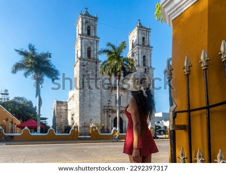 Tourist taking a photo with his mobile phone of the cathedral of San Servacio during the day in the city of Valladolid in Yucatan, Mexico. Clear blue sky.
