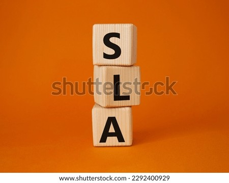 SLA - Service Level Agreement. Wooden cubes with word SLA. Beautiful orange background. Business and Service Level Agreement concept. Copy space.