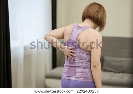 Pain between the shoulder blades, woman suffering from backache at home, health problems concept Royalty-Free Stock Photo #2292409237