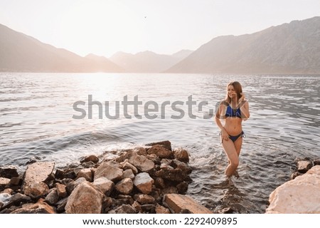 Happy blonde woman puts her face in the sun on the islands in the Adriatic Sea. Girl on vacation in Montenegro.