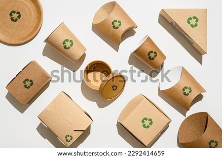Disposable paper tableware with a recycling sign on a white background. The concept of recycling and environmental protection. Royalty-Free Stock Photo #2292414659