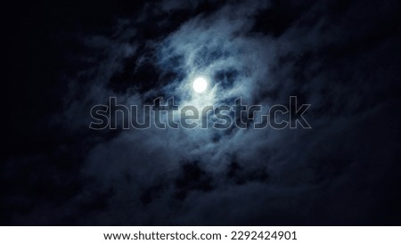 Night sky with full moon for background, concept of horror, Halloween, mystery and nature. Dramatic spooky clouds in moonlight from full moon. Dark gothic sky wallpaper.