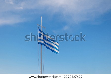 Greece flag is flying in air on blue sky background. Banner, place for text. High quality photo