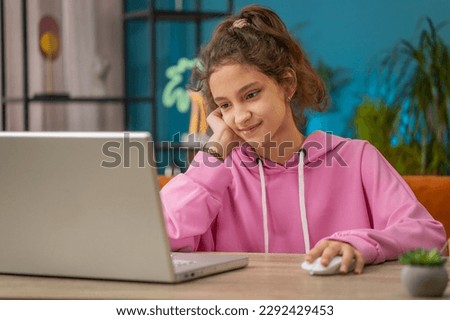 Caucasian preteen school girl using laptop for online lesson, doing homework. Distance learning education. Young child, kid at home workplace sitting at the table. Video call by webcam on internet Royalty-Free Stock Photo #2292429453
