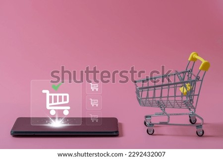 shopping online and e-commerce concept. A small empty shopping cart and Online shopping icon on smartphone on pink background. Online payment and Internet banking on mobile phone application.