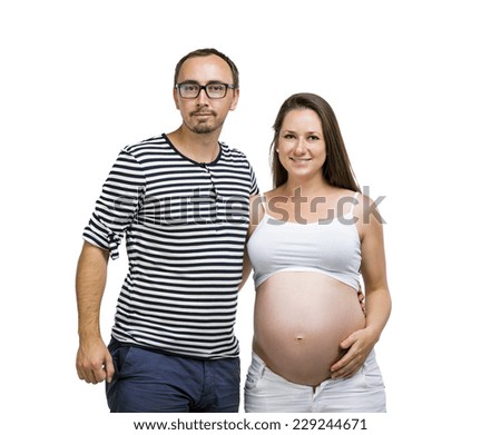 Portrait of young pregnant couple posing in studio, isolated on white background