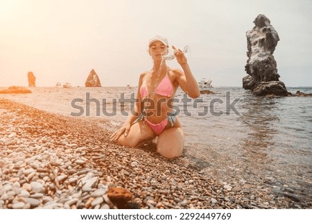 Woman travel sea. Traveler woman captures sea memory in pink bikini. Happy tourist poses on beach amidst volcanic mountains for adventurous journey.