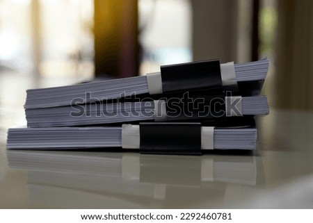
A stack of papers on the table waiting to be reviewed by the supervisor and confirmed for correctness so that the secretary can revise.soft and selective focus.                               