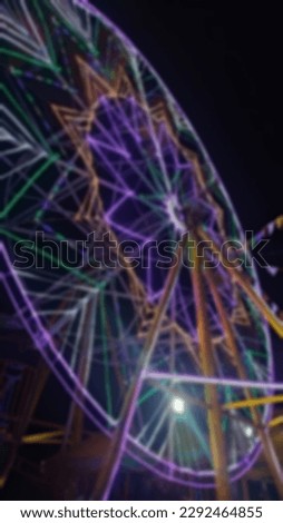 Blurred photos of the Ferris Wheel decorated with beautiful colorful lights are often found in night market entertainment venues