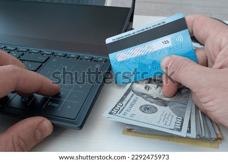 Man holding credit card in hand and entering security code using laptop keyboard. shopping online or transferring money between bank accounts. Royalty-Free Stock Photo #2292475973