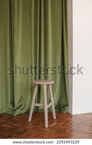 Wooden stool near fabric backdrop. Interior mockup.