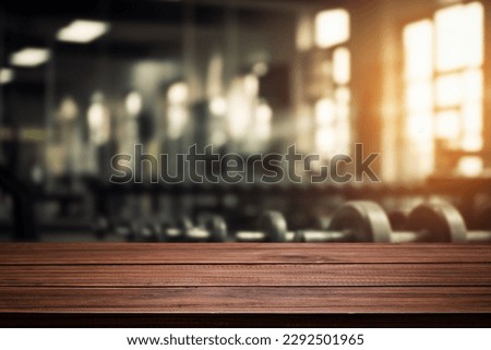 Blurred background of fitness gym and wooden table free space for product display. Royalty-Free Stock Photo #2292501965