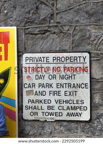 No Parking Sign with the description "private property, strictly no parking day or night car park entrance and fire exit parked vehicles shall be clamped or towed away" found in Galway City Ireland 