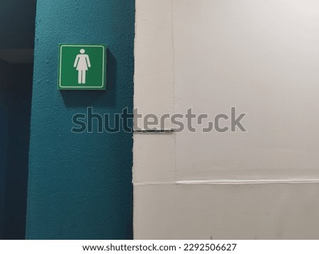 Women's restroom sign, green sign