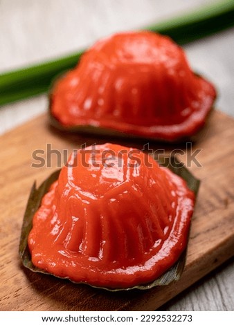 Kue Angku Kue Ku an Indonesian Traditional cake served on a wooden tray at wooden table. an oval shaped pastry with soft, sticky glutinous rice flour skin wrapped around a sweet central filling. Royalty-Free Stock Photo #2292532273
