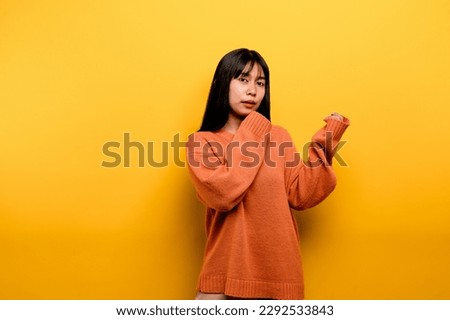 Cute Asian girl smiling on yellow background. Empty, young woman. Place for advertisement. copy space