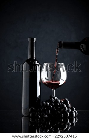 front view bottle of wine pouring into wineglass on dark desk color alcohol photo grape drink Royalty-Free Stock Photo #2292537415