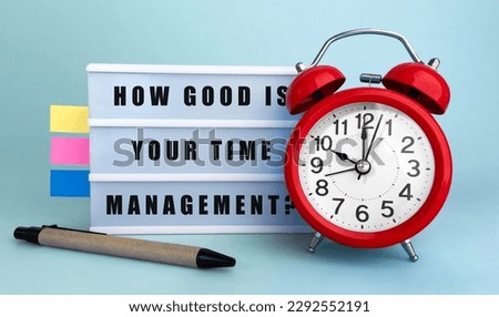Text HOW GOOD IS YOUR TIME MANAGEMENT written on the lightbox with alarm clock and colorfull stickers on blue background