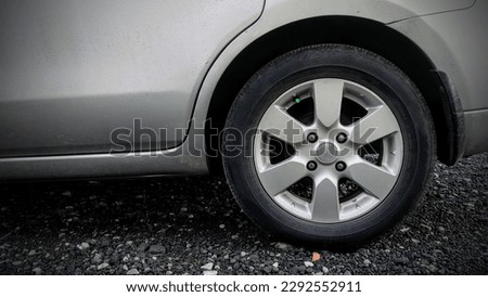 The rear wheel of the car with a pedestal of small rocks Royalty-Free Stock Photo #2292552911