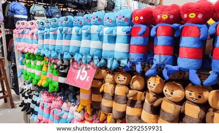 Various types of dolls neatly arranged in a shop window are ready to be made as gifts for loved ones