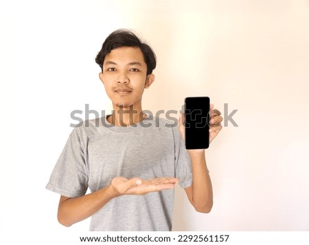 Asian young man showing smartphone with blank screen