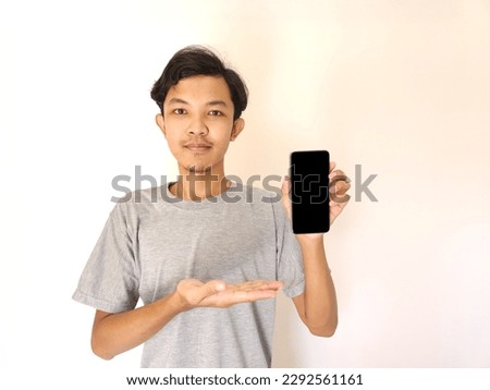 Asian young man showing smartphone with blank screen