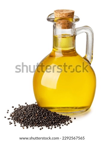 rapeseed oil in glass bottle with heap of dry rape seeds isolated on white background Royalty-Free Stock Photo #2292567565