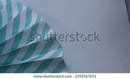 wavy patterned, aqua or light blue colored paper decoration isolated white background vertical