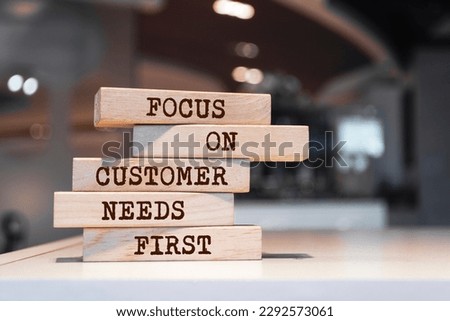 Wooden blocks with words 'Focus on customer needs first'. Business concept Royalty-Free Stock Photo #2292573061