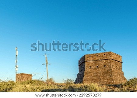 A blockhouse on a hill guarded Prieska during the Second Boer War. It was built from semi-precious tigers eye stones. A telecommunications tower is visible Royalty-Free Stock Photo #2292573279