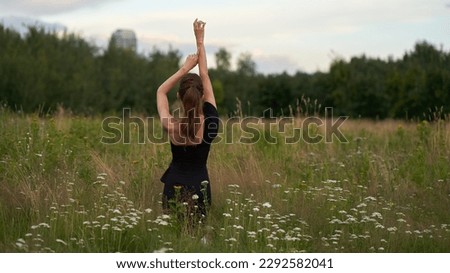 Young woman raising her arms up feeling free in the park. Happiness and joy concept.
