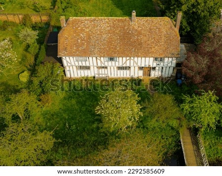 Drone view of a large, detached English period house dating from late medieval times. Showing the period timbers and small bridge accessing the house. Royalty-Free Stock Photo #2292585609