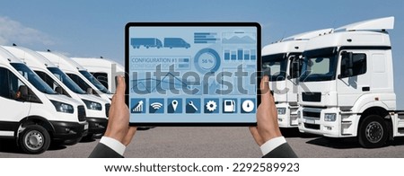 Manager with a digital tablet on the background of vans and trucks. Fleet management