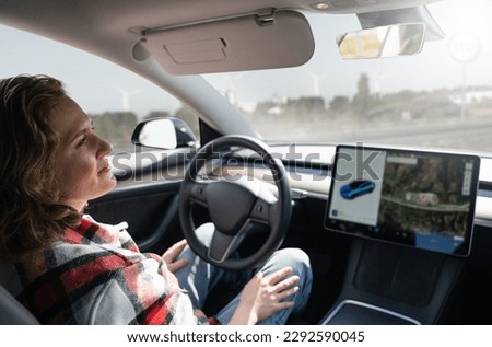 Woman resting while her car is driven by an autopilot. Self driving vehicle concept Royalty-Free Stock Photo #2292590045