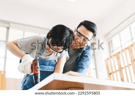Southeast asian family father and son diy or repair at home concept. Dad teach using tools about carpenter or engineer education skill with child at workshop. Royalty-Free Stock Photo #2292595805