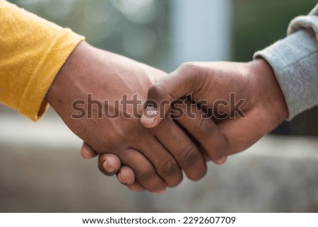 Two hands are holding the handset together and the background is blurred