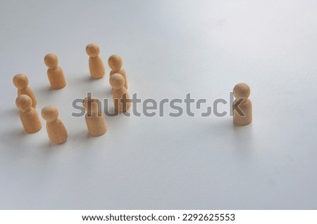 A wooden figure isolated from the rest of the wooden figures Royalty-Free Stock Photo #2292625553