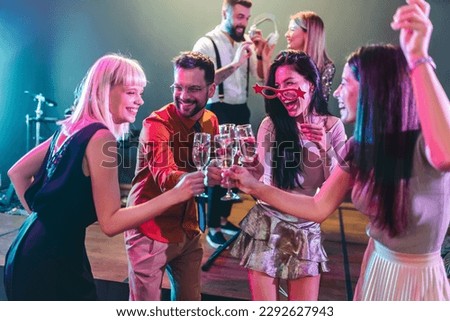 Group of people dancing in the club with DJ in background