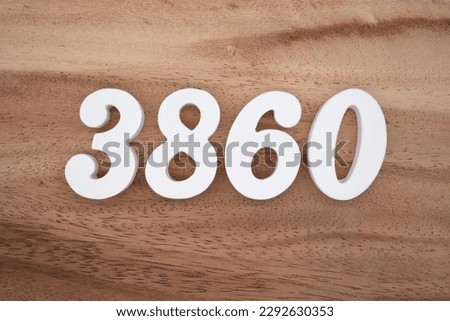 White number 3860 on a brown and light brown wooden background.