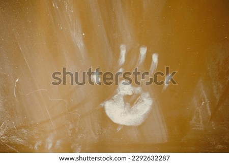 A child's palm print and dirt on the window glass from hands. Traces of baby's greasy hands on the mirror Royalty-Free Stock Photo #2292632287