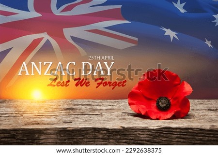 Poppy pin for Anzac Day. Poppy flower on old beautiful high grain, detailed wood on background of sunset sky and transparent Australia flag. Anzac Day Lest We Forget. Royalty-Free Stock Photo #2292638375