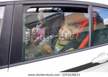 Cute children, boy and girl siblings, sitting in car seats in car, traveling. Family going to family vacation